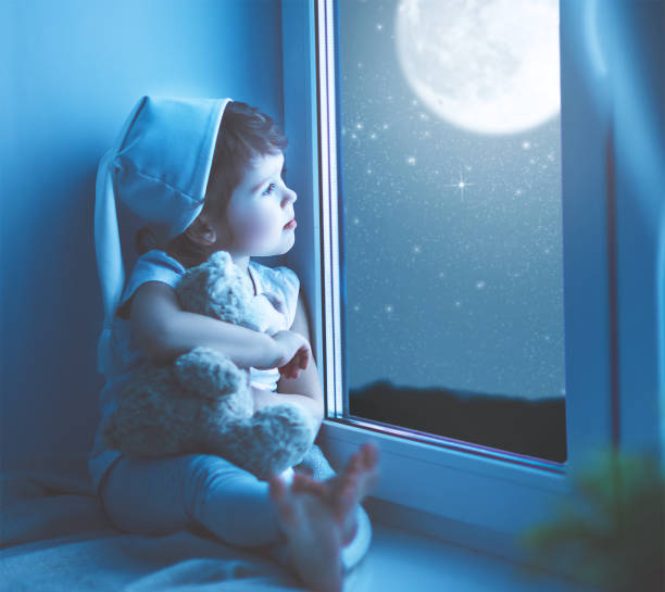 istock child girl at window dreaming starry sky at bedtime 657928880