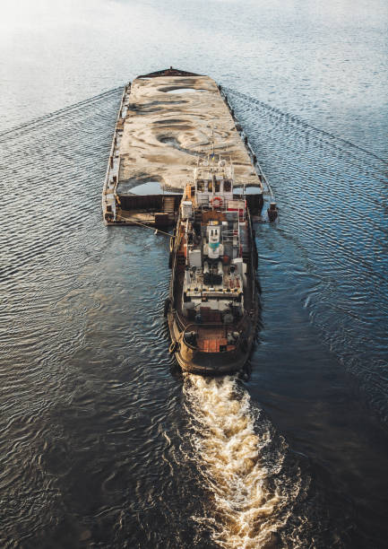 istock Tugboat pushing barge with sand 657964858