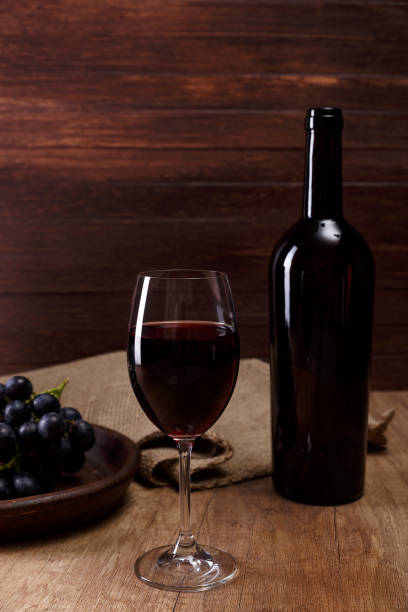 istock Red wine. Wineglass with grapes branch. 657965338