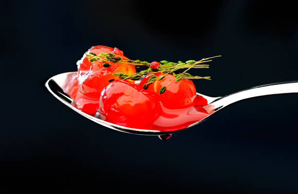 świecąca metalowa łyżka z kulkami intensywnych czerwonych wiśni - dried cherries zdjęcia i obrazy z banku zdjęć