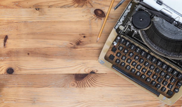 istock Old typewriter and pencil on wooden desk 657971714