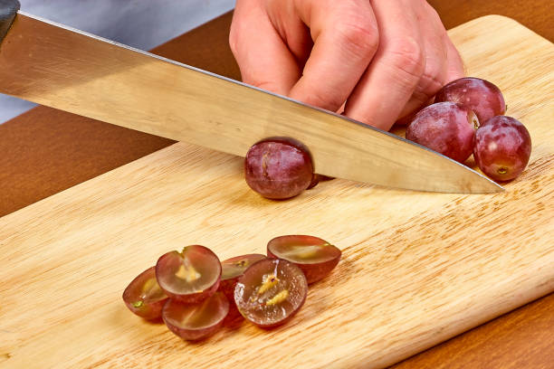 istock Chef sliced grapes on a cutting board Chef's hands Close-up 657972064