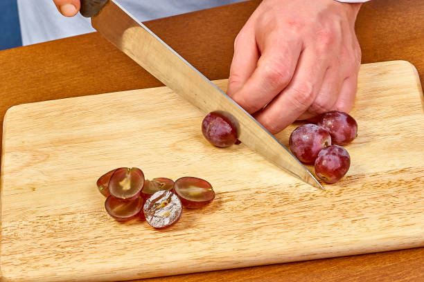 istock Chef sliced grapes on a cutting board Chef's hands Close-up 657972080