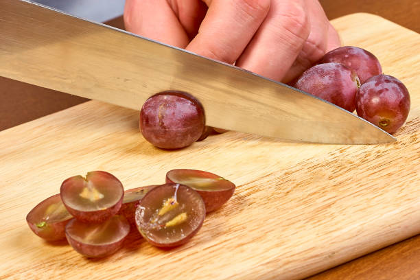 istock Chef sliced grapes on a cutting board Chef's hands Close-up 657972092