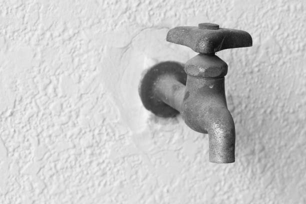 istock Old faucet next to a white wall. 657981572