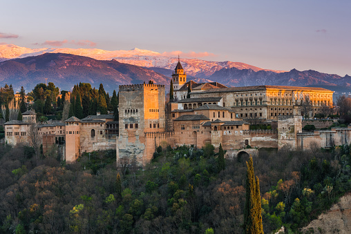 Arabic palace Alhambra in Granada,Spain at twilight with Sierra Nevada mountains in background