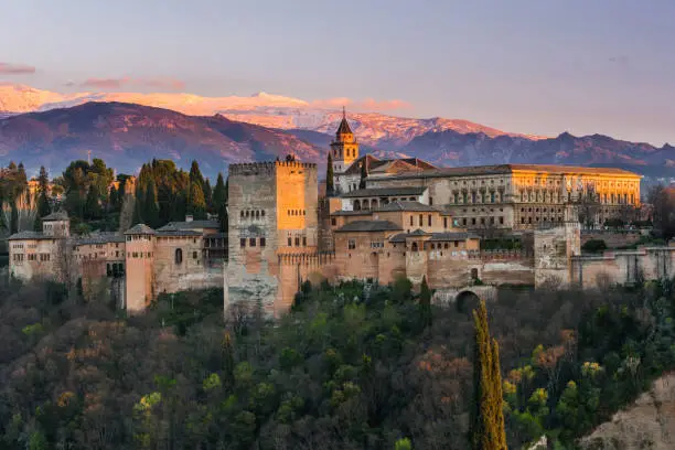 Arabic palace Alhambra in Granada,Spain at twilight with Sierra Nevada mountains in background