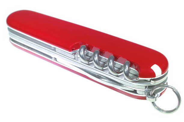 Red all purpose pocket knife on a rustic wooden background. Top view
