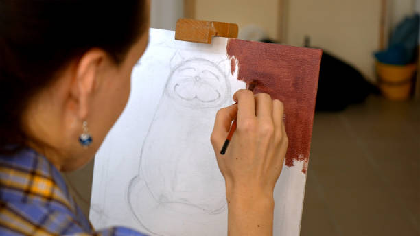 istock Female artist paints picture artwork in art studio 657994674
