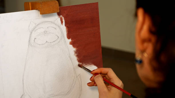 istock Female artist paints picture artwork in art studio 657996166