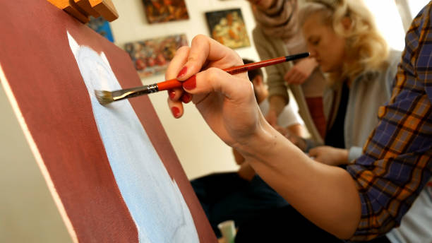 istock Female artist paints picture artwork in art studio 657996298