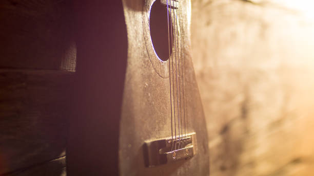 istock Acoustic guitar leaning on grungy wooden wall 658002432