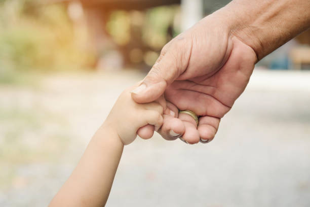 Father and son holding hands together. stock photo