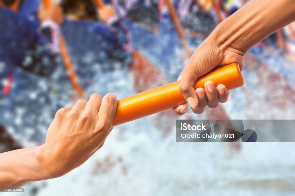 manos pasando un bastón de relevo en el fondo del equipo de remo y efecto de tono de color. - Foto de stock de Remar libre de derechos