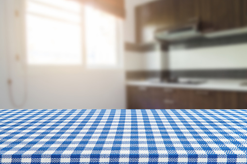Empty table with tablecloth and blurred kitchen background, product montage display.