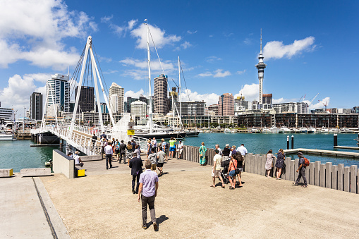 AUCKLAND, NEW ZEALAND - MARCH 1, 2017: People cross the bridge that links the Wynyard district to the Viaduct Marina in Auckland, New Zealand largest city.