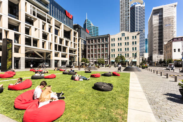 AUCKLAND, NEW ZEALAND - MARCH 1, 2017: People relax on garden sofas in a park in Britomart in downtown in Auckland, New Zealand largest city on a sunny day.