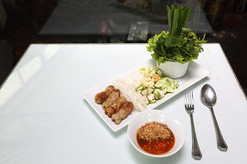 Vietnamese Food in Restaurant white plate on the Table with side dish, Ingredients of Vietnamese Wraps or Pork Sausage, Nam Naung, Ban Hoi
