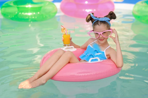 portrait of little girl in tropical style in a swimming pool - 16312 imagens e fotografias de stock