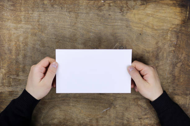 istock male hands holding a white blank sheet of paper 658054554