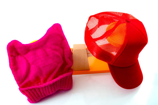 Political division and a divided country concept, illustrated by the pink hat representing the liberals and the red trucker hat representing the conservatives in an increasingly partisan America