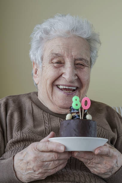 istock Senior woman with her birthday cake for age eighty 658068210