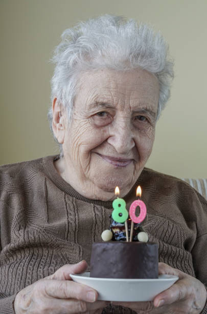 istock Senior woman with her birthday cake for age eighty 658068212