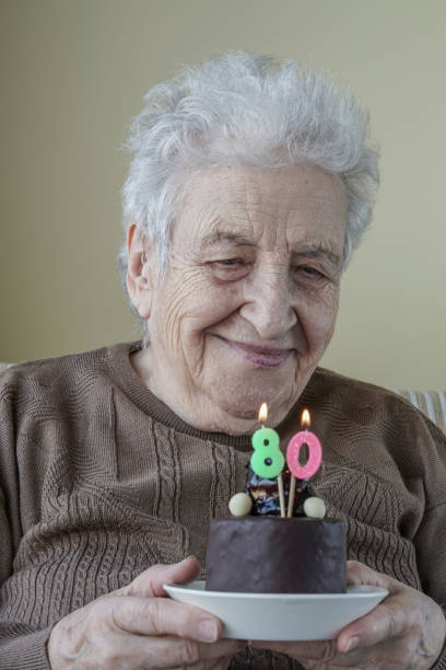 istock Senior woman with her birthday cake for age eighty 658068214