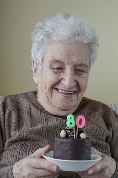 istock Senior woman with her birthday cake for age eighty 658068226