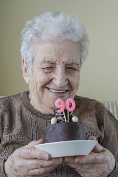 istock Senior woman with her birthday cake for age ninety 658068620