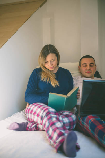istock Lauhing lovers surfing the internet in the bedroom 658071826