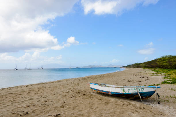 Weathered boat on a beach on the island of Saint Kitts and Nevis in the caribbean. Large yachts and sail boats can be seen in the background.  The island of Nevis is at a distance behind the mountains.Panoramic of the beach at Frigate Bay on the island of Saint Kitts (St. Kitts and Nevis). Sail boats and a cruise ship can be seen in the bay with the mountain of the island of Nevis in the background.Weathered boat on a beach on the island of Saint Kitts and Nevis in the caribbean. Large yachts and sail boats can be seen in the background.  The island of Nevis is at a distance behind the mountains.