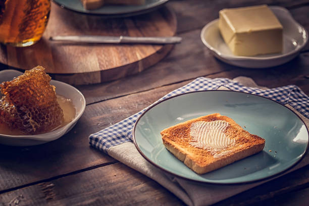 Preparing toast with butter and delicious honey for breakfast