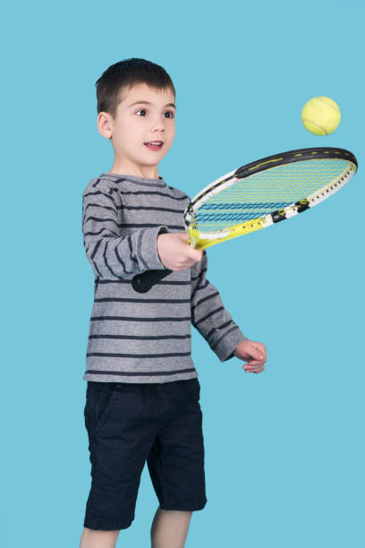 little boy playing in tennis with racket, isolated - tennis teenager little boys playing imagens e fotografias de stock