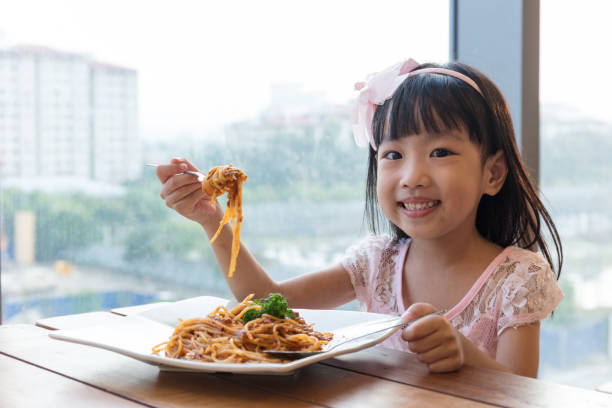 niña china asiática comiendo espaguetis boloñesa - west china fotografías e imágenes de stock