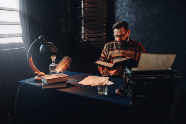 istock Bearded author in glasses reading a book 658122458