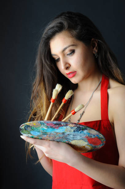 istock Woman Holding up Brushes and Palette 658122884