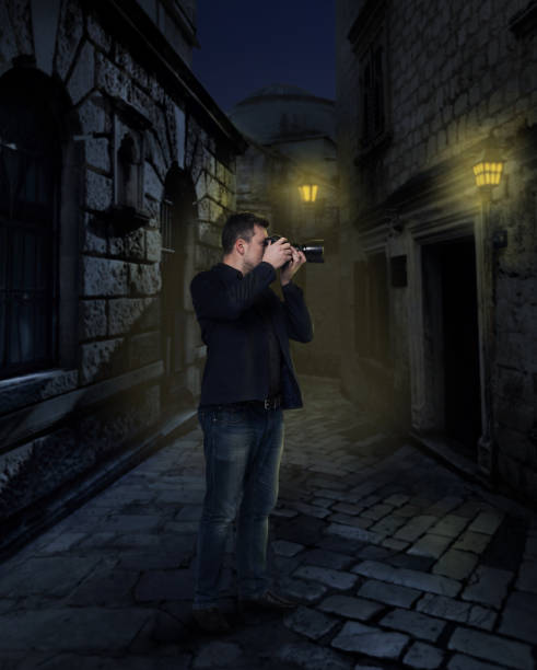 istock Photographer with digital camera in night alley 658123676