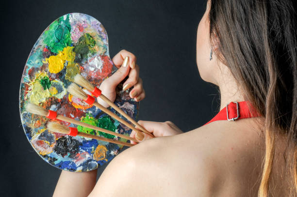 istock Woman Holding up Brushes and Palette 658126824