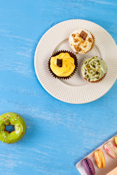 Cupcakes with buttercream. Macaroons and donut.