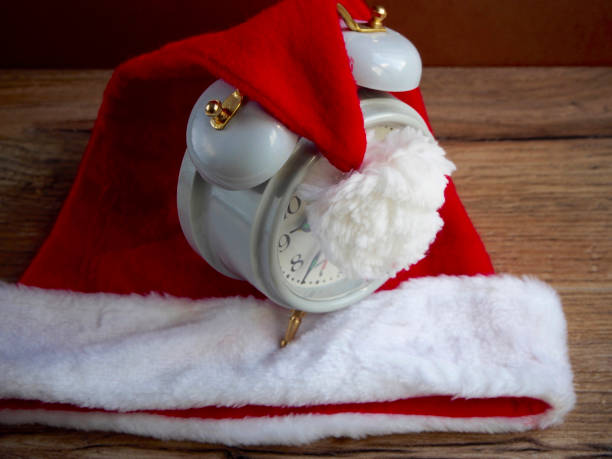 istock Santa Claus hat with clock on wood background 658137674
