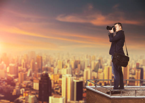 istock Photographer with digital camera against cityscape 658140760