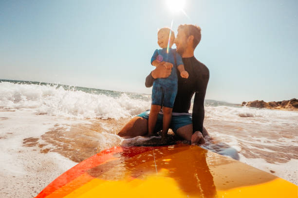 learning a surf - surfing beach family father fotografías e imágenes de stock