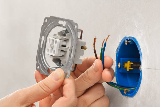 istock hands of electrician installing light switch in plasterboard wall 658160548