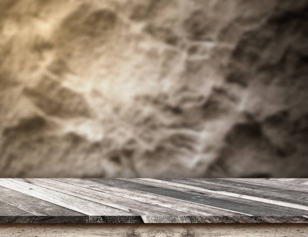 istock diagonal wooden plank table top at blurred rough stone wall,Template mock up for display or montage of product 658164074