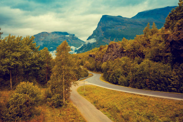 istock Road among mountains with dramatic stormy cloudy sky 658174682