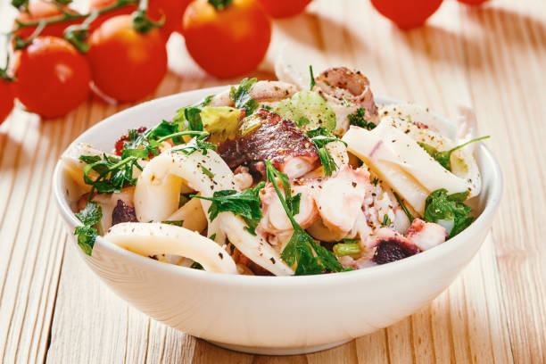 Seafood salad in white bowl on wooden table