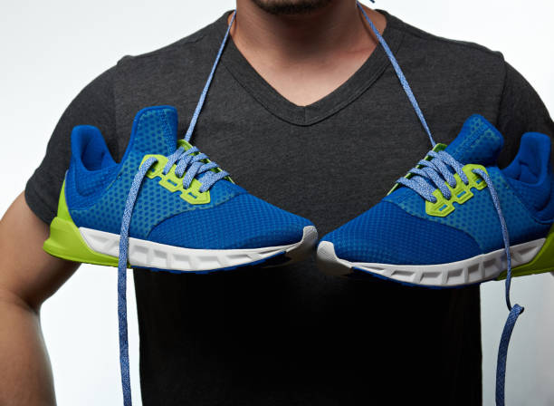 istock Man with hanging shoes on neck 658184362