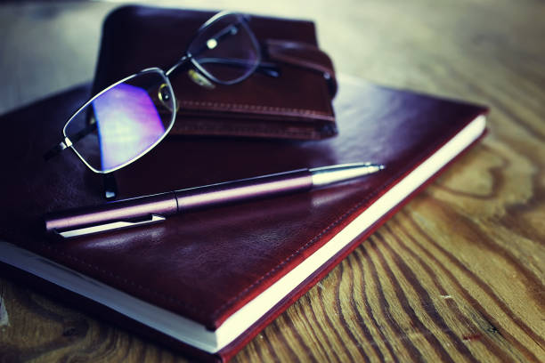 notebook con occhiali da penna aziendale - macro book laptop office foto e immagini stock