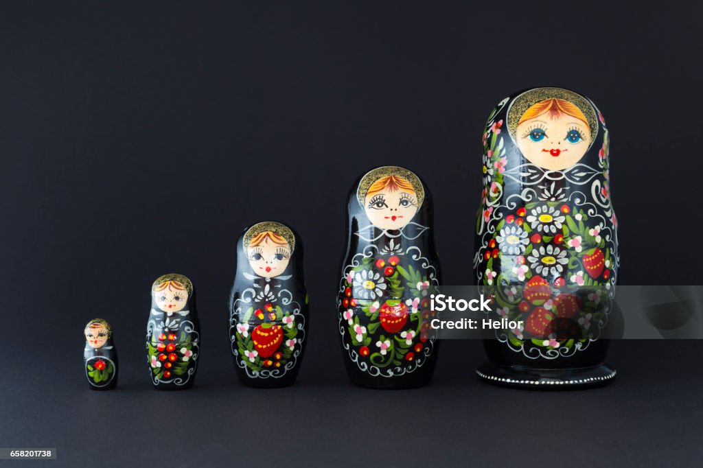 Beautiful black russian nesting dolls Beautiful black russian nesting dolls (matryoshka) dolls with white, green and red painting in front of dark background Russian Nesting Doll Stock Photo